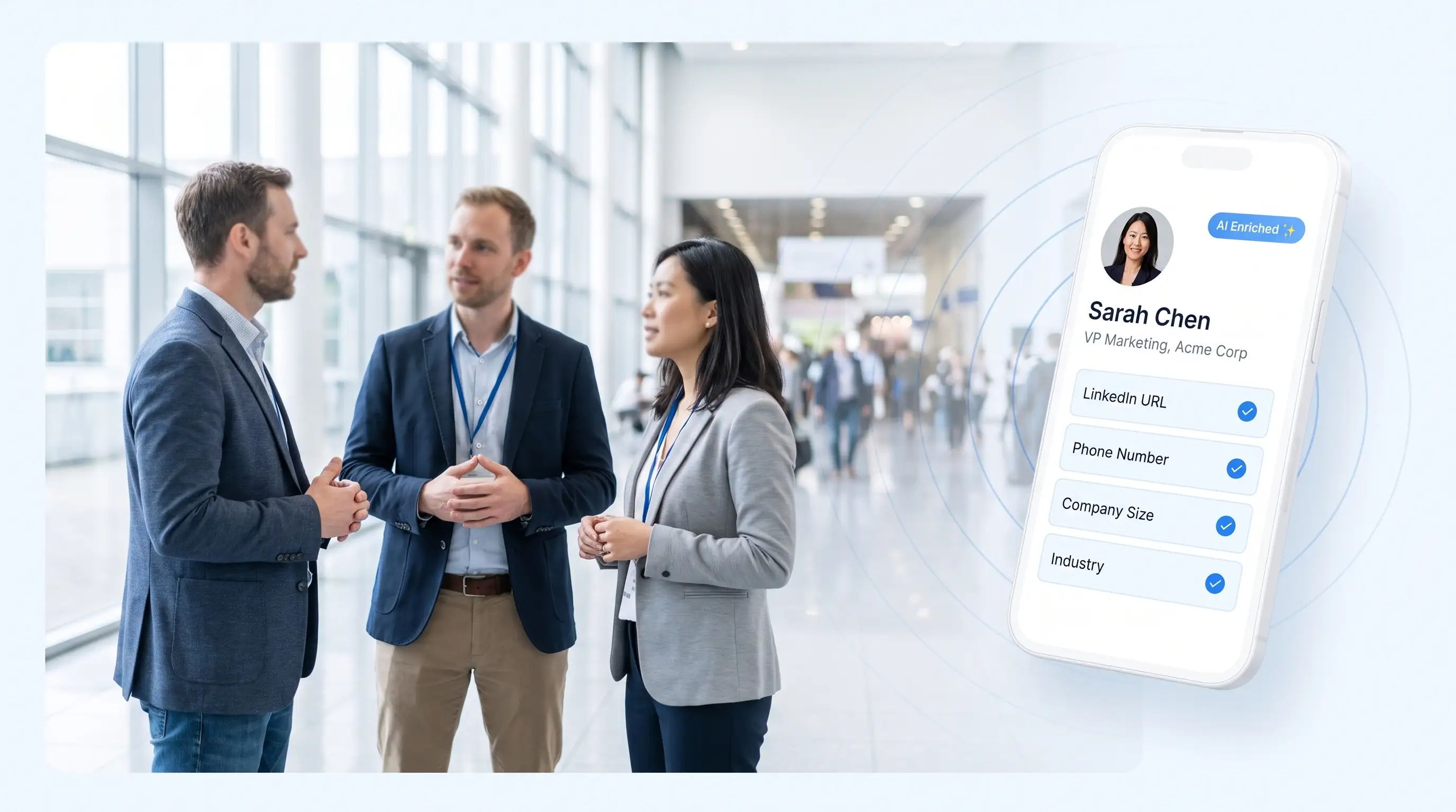 Attendees networking on a conference floor away from the exhibitor booths, with a phone capturing a contact