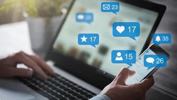 Notebook exibindo notificações de redes sociais na tela.